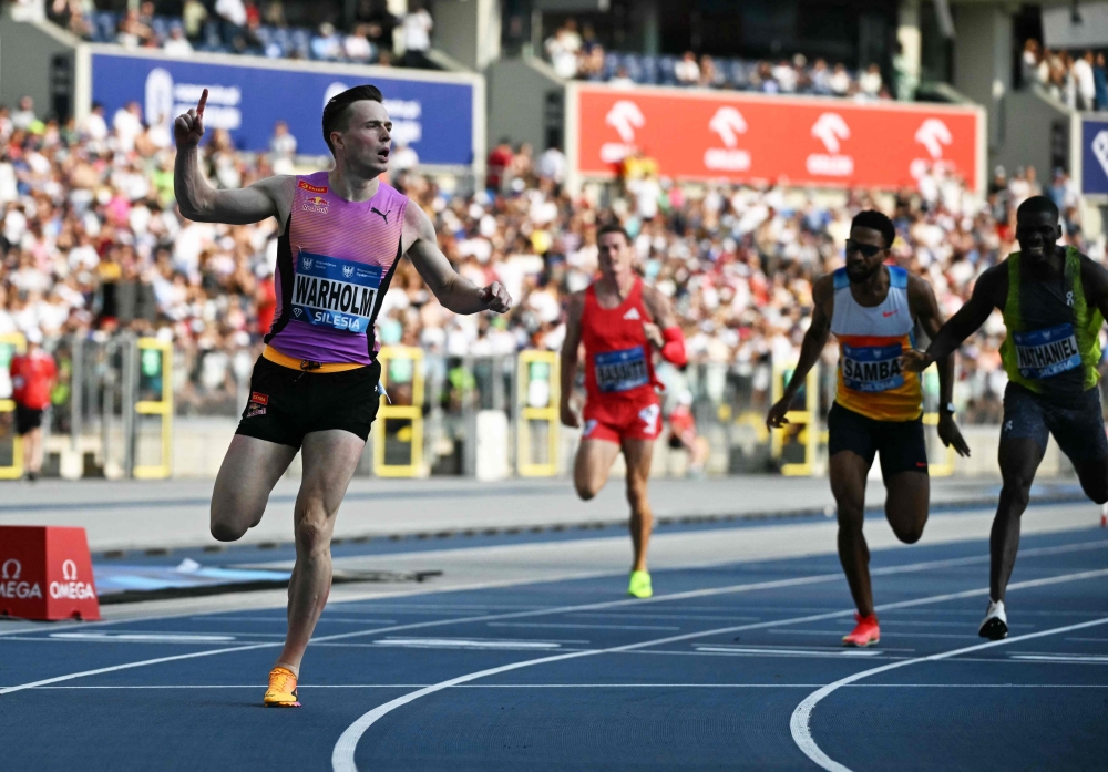 Norway's Karsten Warholm (L) celebrates as he wins the men's 400m hurdles event of the Silesia Diamond League athletics meeting in the Stadion Slaski in Chorzow, Poland, on August 16, 2025. (Photo by Sergei Gapon / AFP)
 