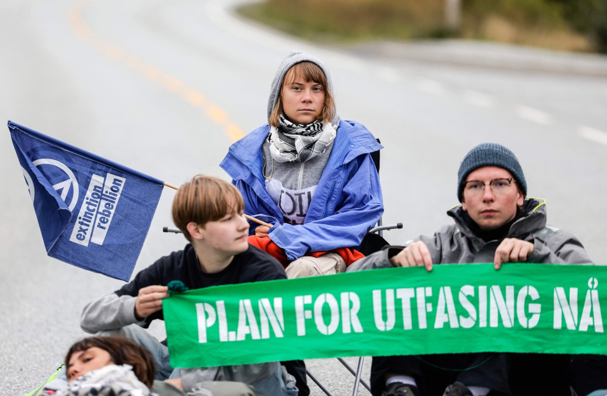 Swedish climate and political activist Greta Thunberg (C) and activists from the climate protest group Extinction Rebellion take part in a protest at Equinor's oil refinery in Mongstad, north of Bergen, Norway on August 18, 2025. Photo by Paul S. Amundsen / NTB / AFP