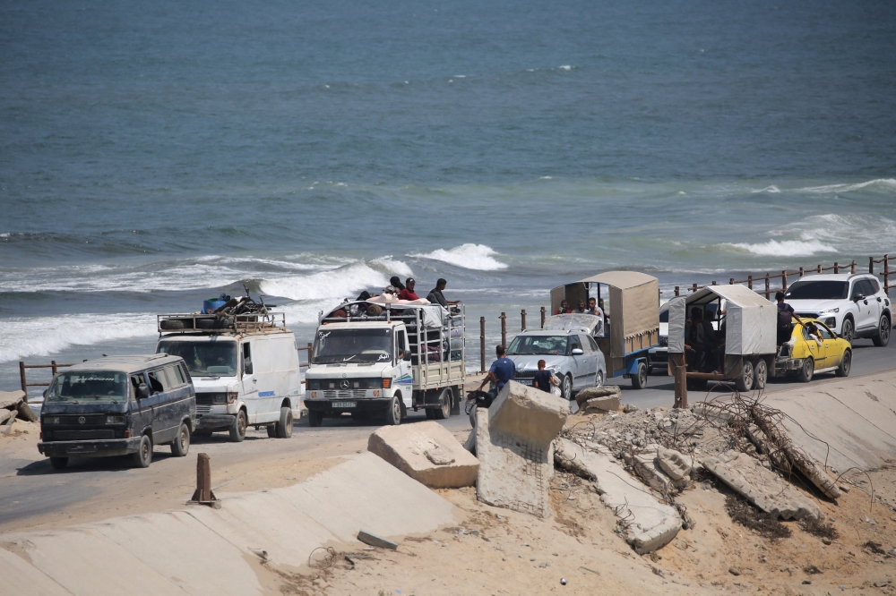 Palestinian families arrive with their belongings in the Nuseirat in the central Gaza Strip on August 18, 2025, as they flee their homes in Gaza City heading toward the south. (Photo by Eyad Baba / AFP)