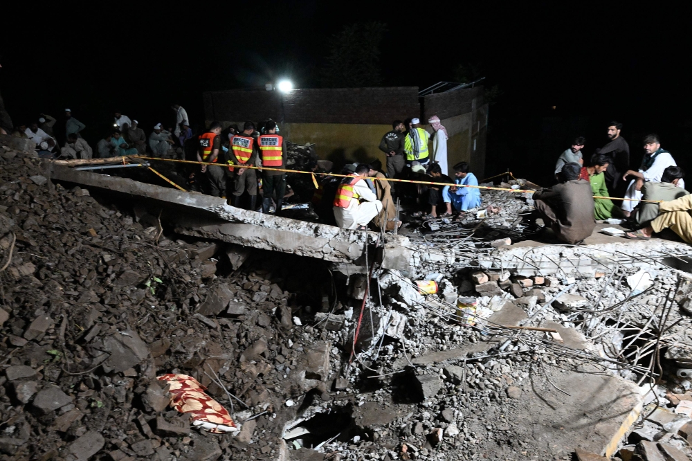 Rescue workers and residents search for victims in the debris of collapsed houses after a cloudburst in Dolari village, Swabi district, in northern Pakistan's mountainous Khyber Pakhtunkhwa province, on August 18, 2025. (Photo by Aamir Qureshi / AFP)
 