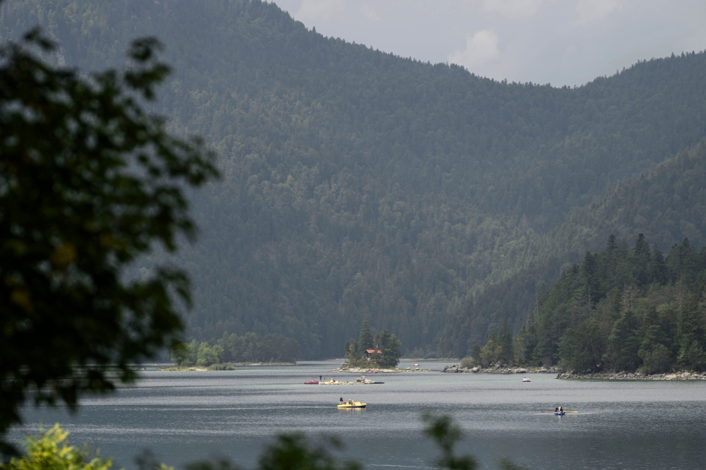 Tourists ride rental boats on the Eibsee lake, near Grainau, Garmisch-Partenkirchen, southern Germany on August 22, 2025. (Photo by Philipp Guelland / AFP)