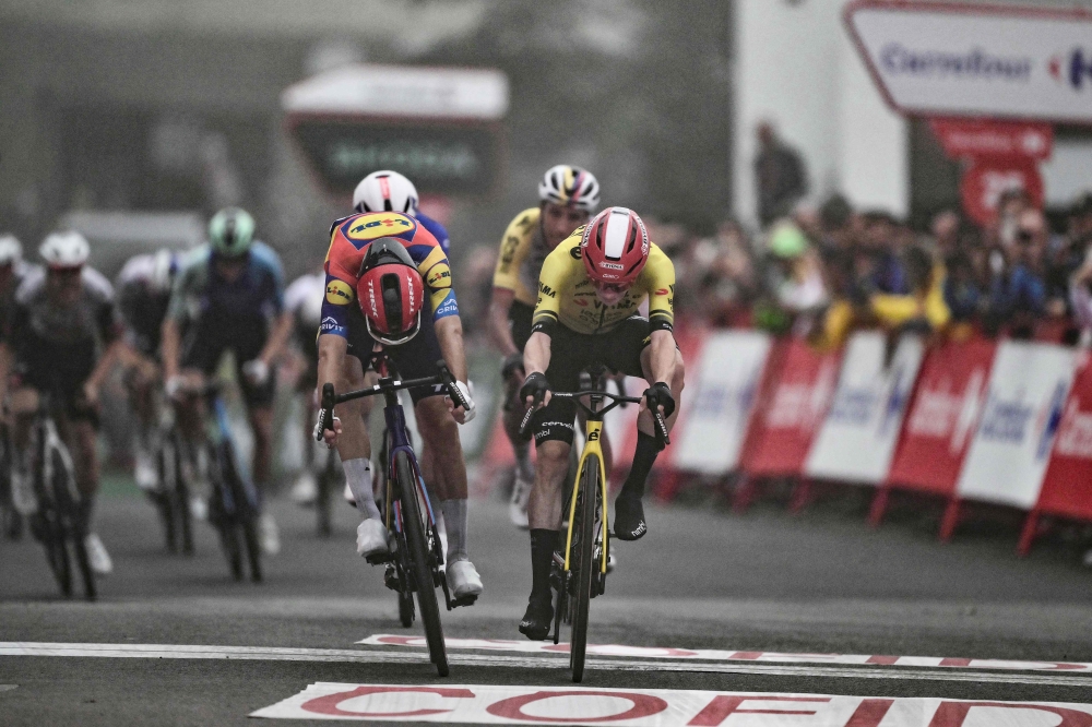 Team Visma-Lease a bike's Danish rider Jonas Vingegaard (R) crosses the finish line during the second stage of the Vuelta a Espana on August 24, 2025. (Photo by Marco Bertorello / AFP)