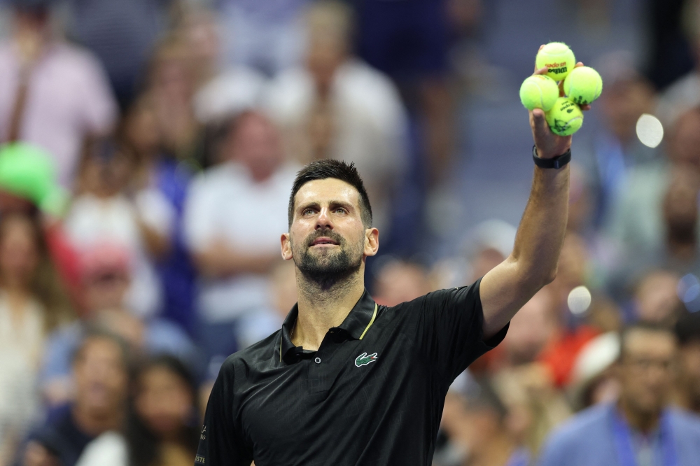 Serbia's Novak Djokovic prepares to throw signed tennis balls to fans after winning his men's singles first round tennis match against USA's Learner Tien in New York City, on August 24, 2025. (Photo by Charly Triballeau / AFP)