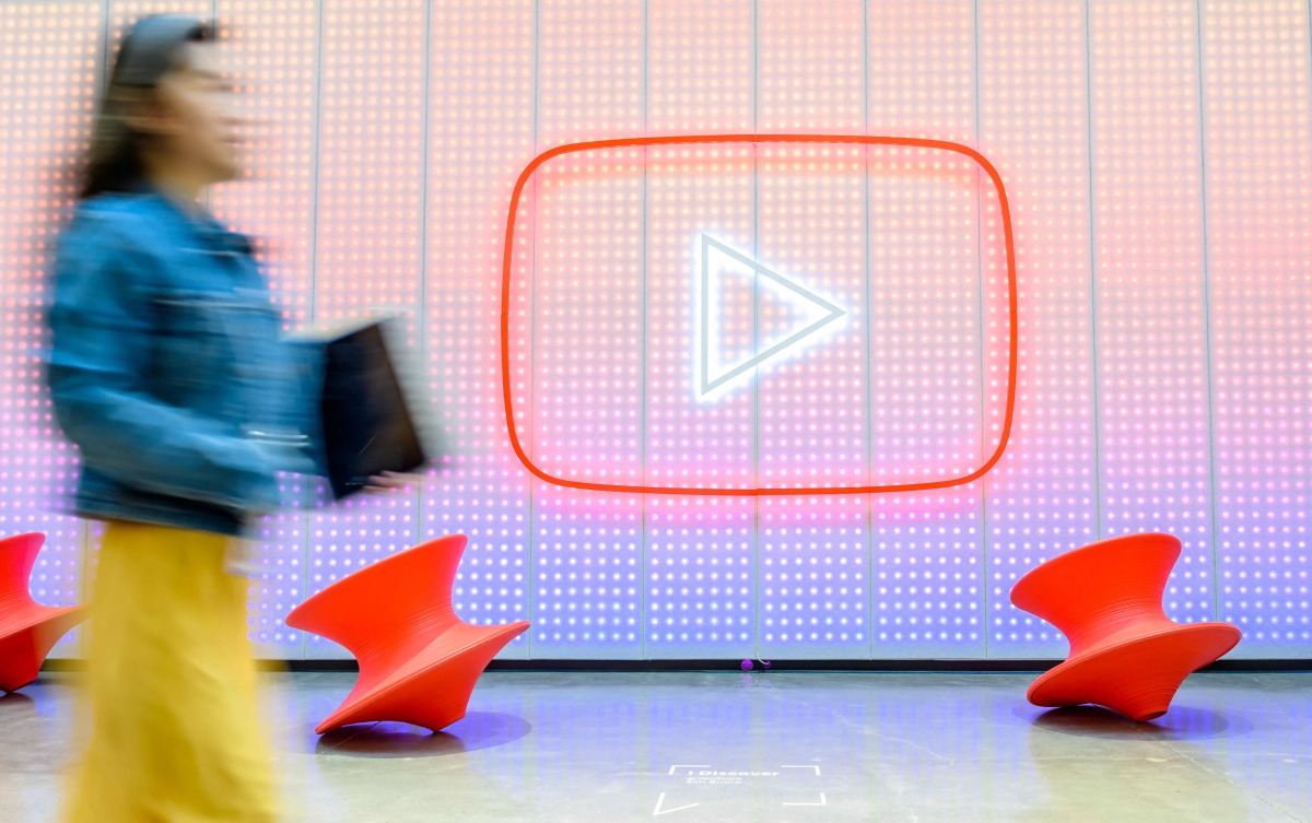 In this file photo taken on April 23, 2025 shows a woman walking by a YouTube logo in San Bruno, California. Photo by JOSH EDELSON / AFP