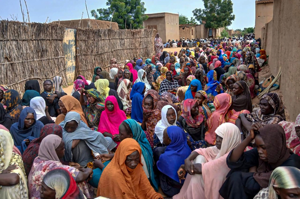 Sudanese gather to receive free meals in El-Fasher, a city besieged by Sudan's paramilitary Rapid Support Forces (RSF) for more than a year, in Darfur region, on August 11, 2025. (Photo by AFP)