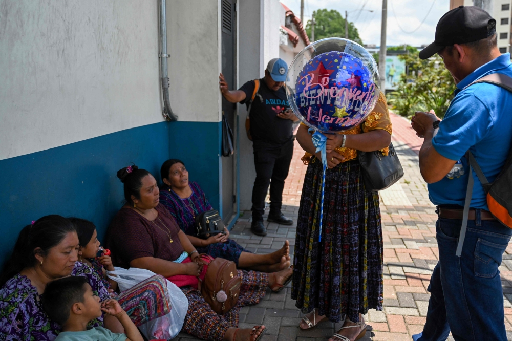 Relatives of minors deported from the United States gather outside of the Returnee Reception Center while waiting for their arrival at the Guatemalan Air Force Base in Guatemala City on August 31, 2025. (Photo by Johan Ordonez / AFP)