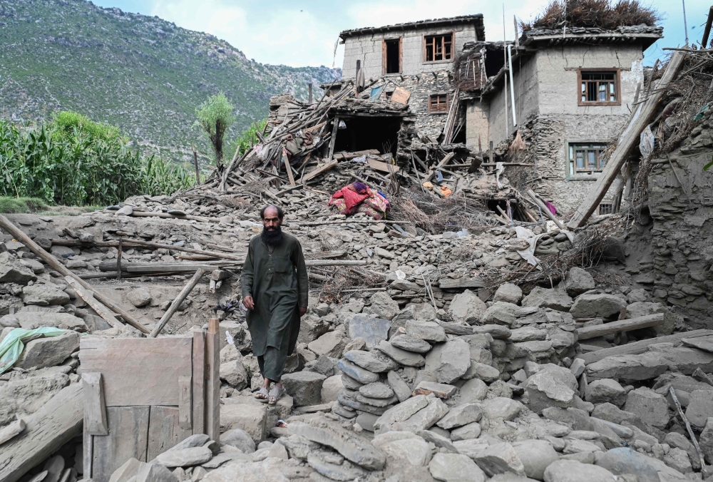 An man Afghan walks past a damaged house following earthquakes in the Mazar Dara village of Nurgal, a district of the Kunar Province, in Eastern Afghanistan, on September 1, 2025. (Photo by Wakil Kohsar / AFP)