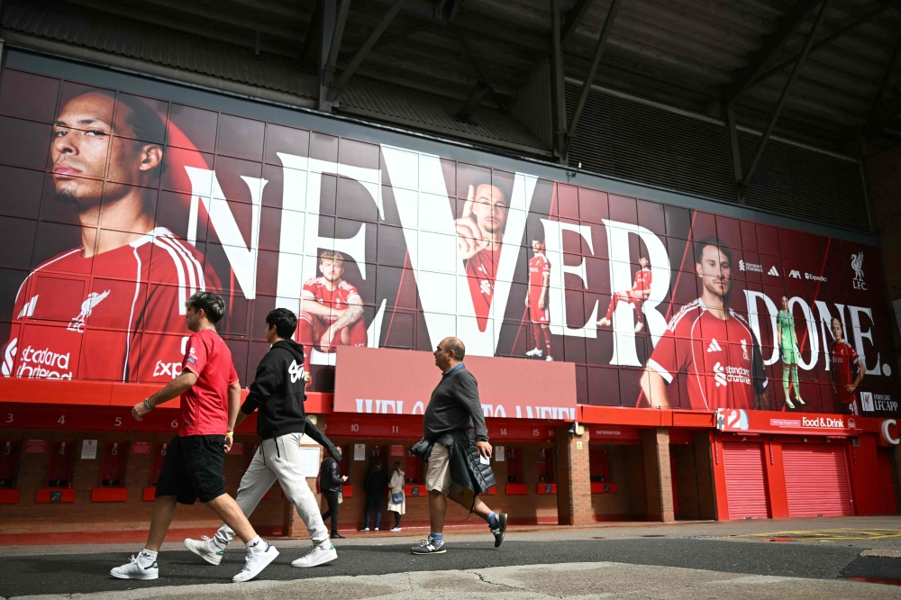 Members of the public walk beside Liverpool's Anfield football stadium on the day that Swedish striker Alexander Isak arrives at the club in Liverpool, north-west England on September 1, 2025, transfer deadline day. (Photo by Paul Ellis / AFP)
