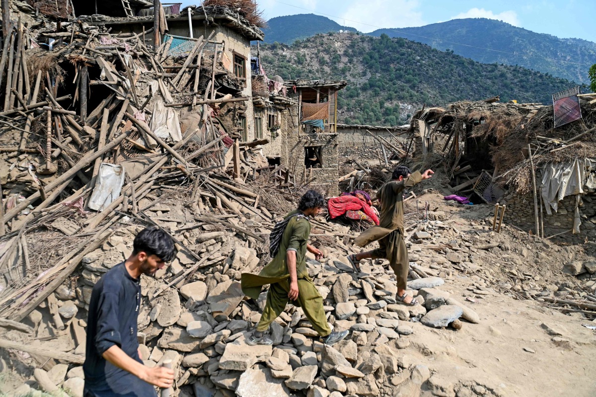 Afghans walk past damaged houses, after earthquakes at Mazar Dara village in Nurgal district, Kunar province, in Eastern Afghanistan, on September 1, 2025. (Photo by Wakil Kohsar / AFP)

