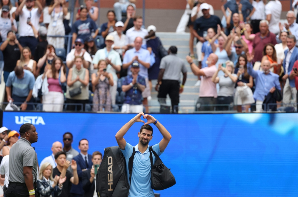 Novak Djokovic of Serbia acknowledges the crowd as he walks off the court after losing to Carlos Alcaraz of Spain on September 5, 2025. Clive Brunskill/Getty Images/AFP 
 