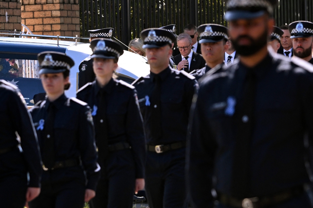 Australia's Prime Minister Anthony Albanese (C) pays his respects as the coffin of police officer Senior Constable Vadim de Waart-Hottart leaves the Victoria Police Academy chapel. (Photo by William West / AFP)