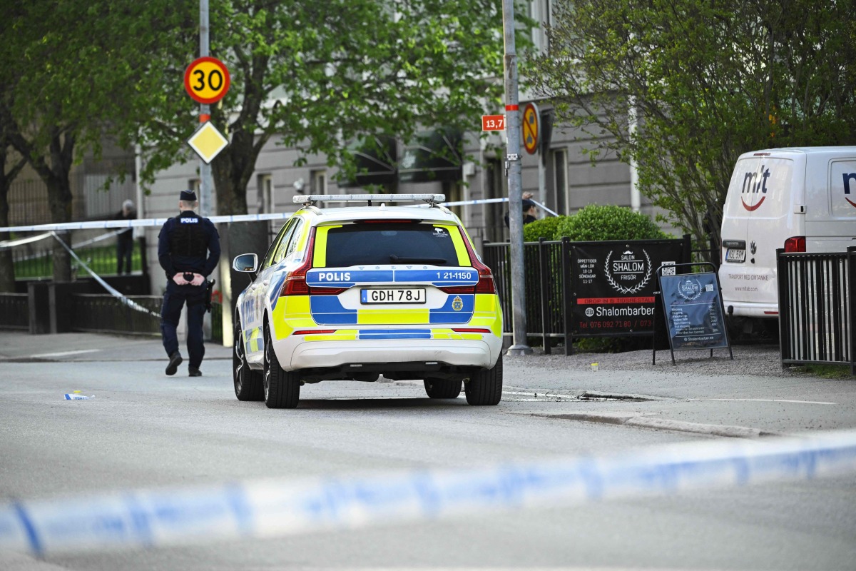 Police officers cordon off the scene after several people were killed in a shooting at Vaksala Square in central Uppsala, Sweden on April 29, 2025. (Photo by Fredrik SANDBERG / various sources / AFP)

