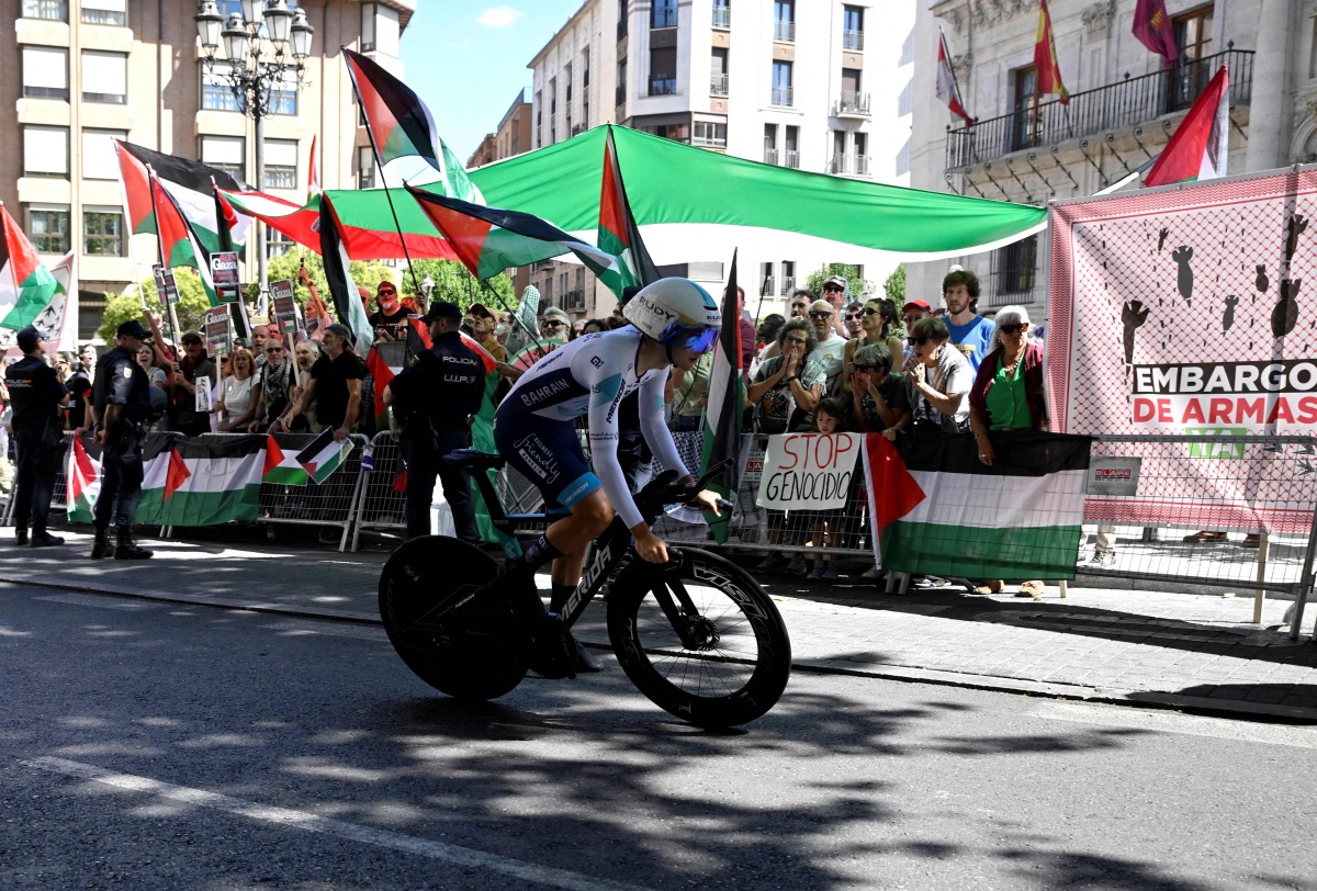 Pro-Palestinians protesters demonstrate as a cyclist competes during the 18th stage of the Vuelta a Espana, yesterday. 