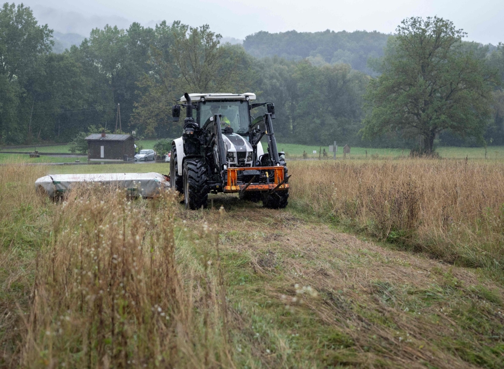 Cattle farmer Josef Hadler mows a meadow with his tractor on the border between Austria and Slovenia on September 10, 2025. (Photo by Joe Klamar / AFP)