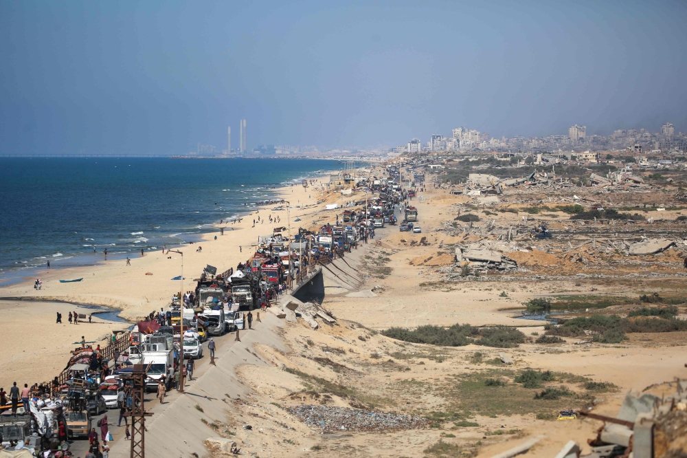 Displaced Palestinians move with their belongings southwards on a road in the Nuseirat refugee camp area in the central Gaza Strip following renewed Israeli evacuation orders for Gaza City on September 14, 2025. (Photo by Eyad Baba / AFP)
