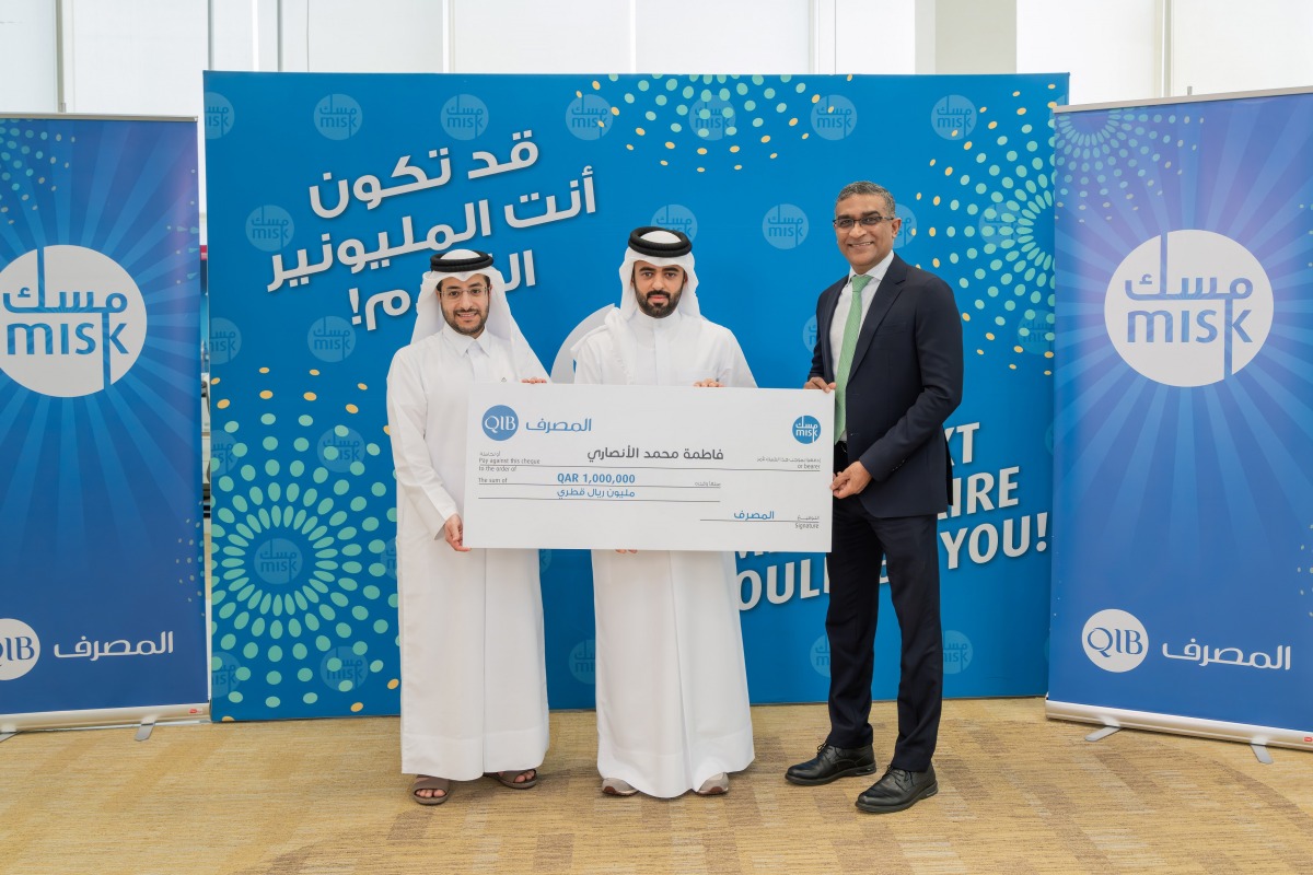 Fatima Mohamed Al-Ansari’s brother receiving the grand prize from QIB officials.