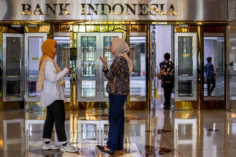 Employees talk in the lobby of Bank Indonesia, the country's central bank, in Jakarta on September 16, 2025. (Photo by Bay Ismoyo / AFP)
