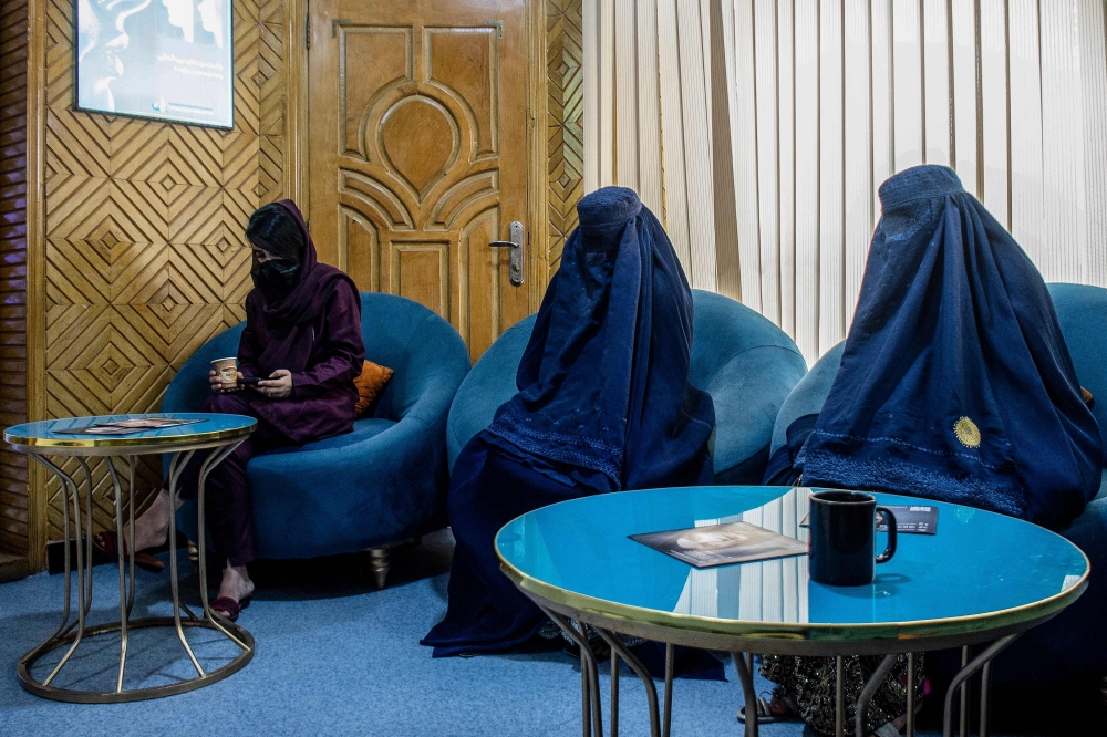 In this photograph taken on August 31, 2025, Afghan burqa-clad women, having appointments for laser treatments, sit in a waiting room at a beauty clinic in Kabul. (Photo by Wakil Kohsar / AFP)
