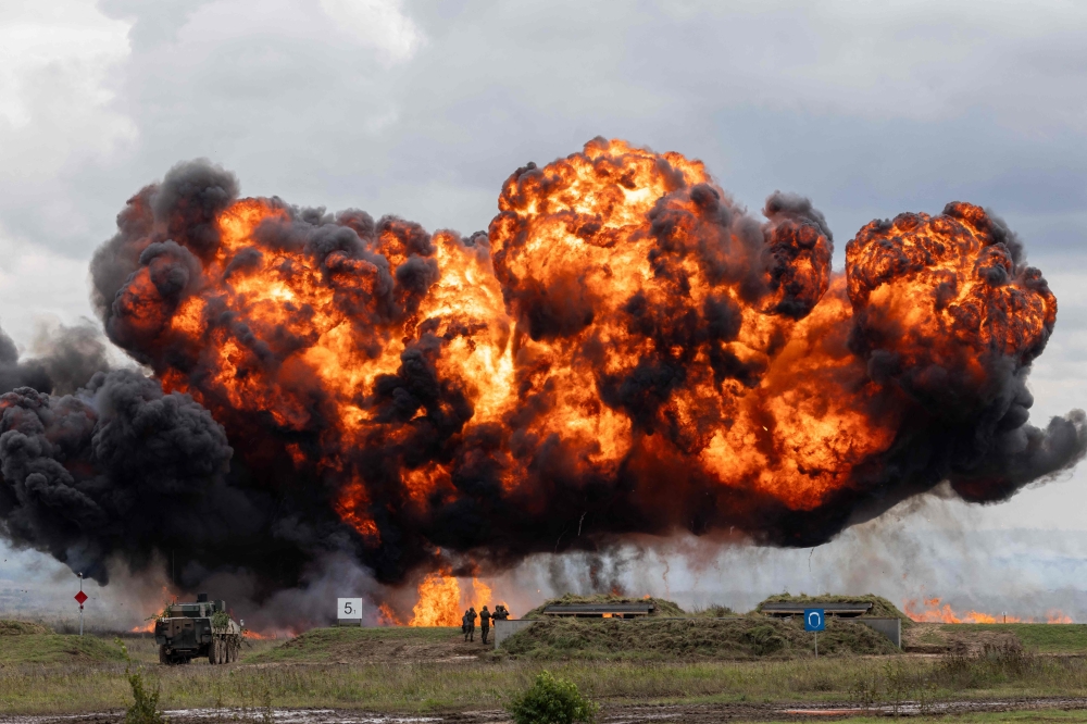 A cloud of smoke and fire rises over the field during military exercises of Poland and NATO allied countries in Orzysz on September 17, 2025. (Photo by Wojtek Radwanski / AFP)
