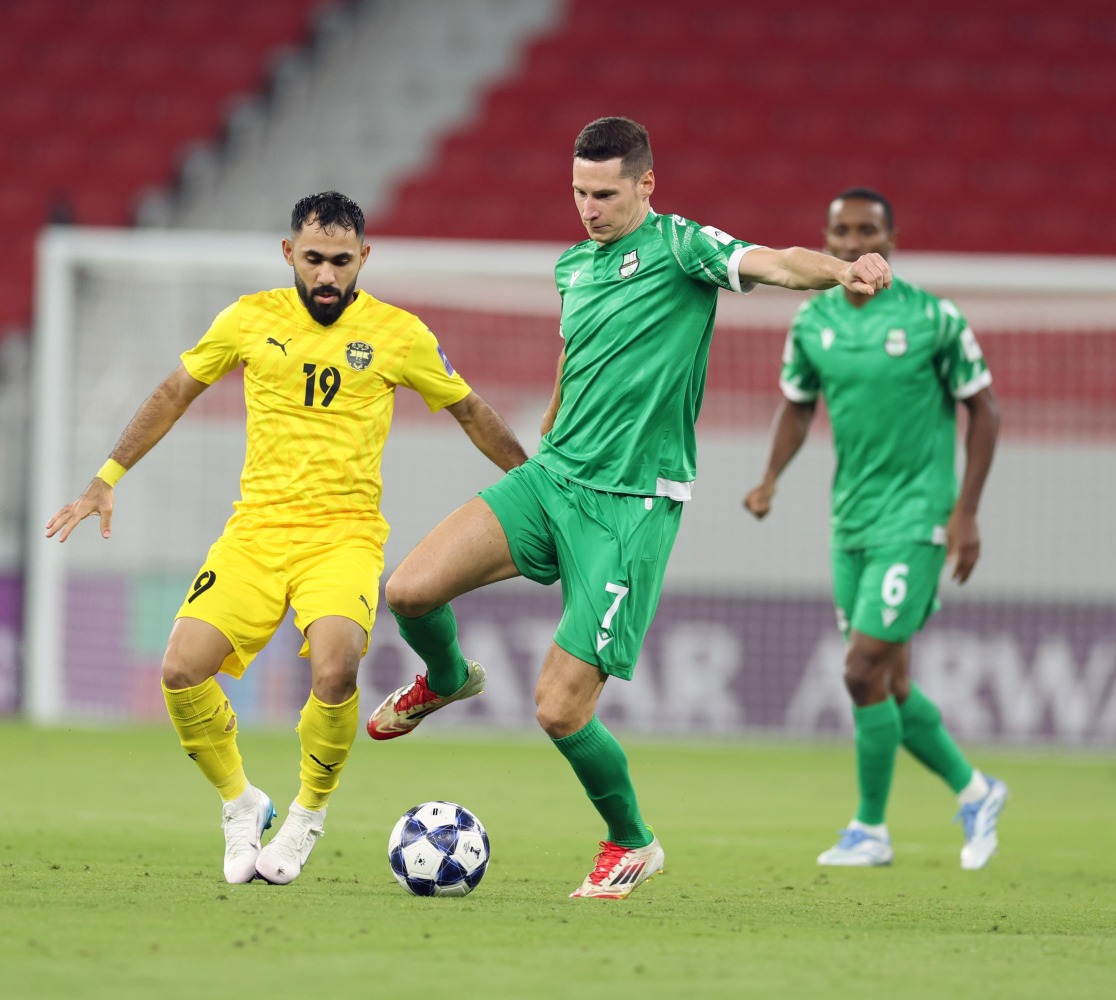 Al Ahli's Julian Draxler (centre) and Al Khaldiya's Komail Al-Aswad fight for the ball.