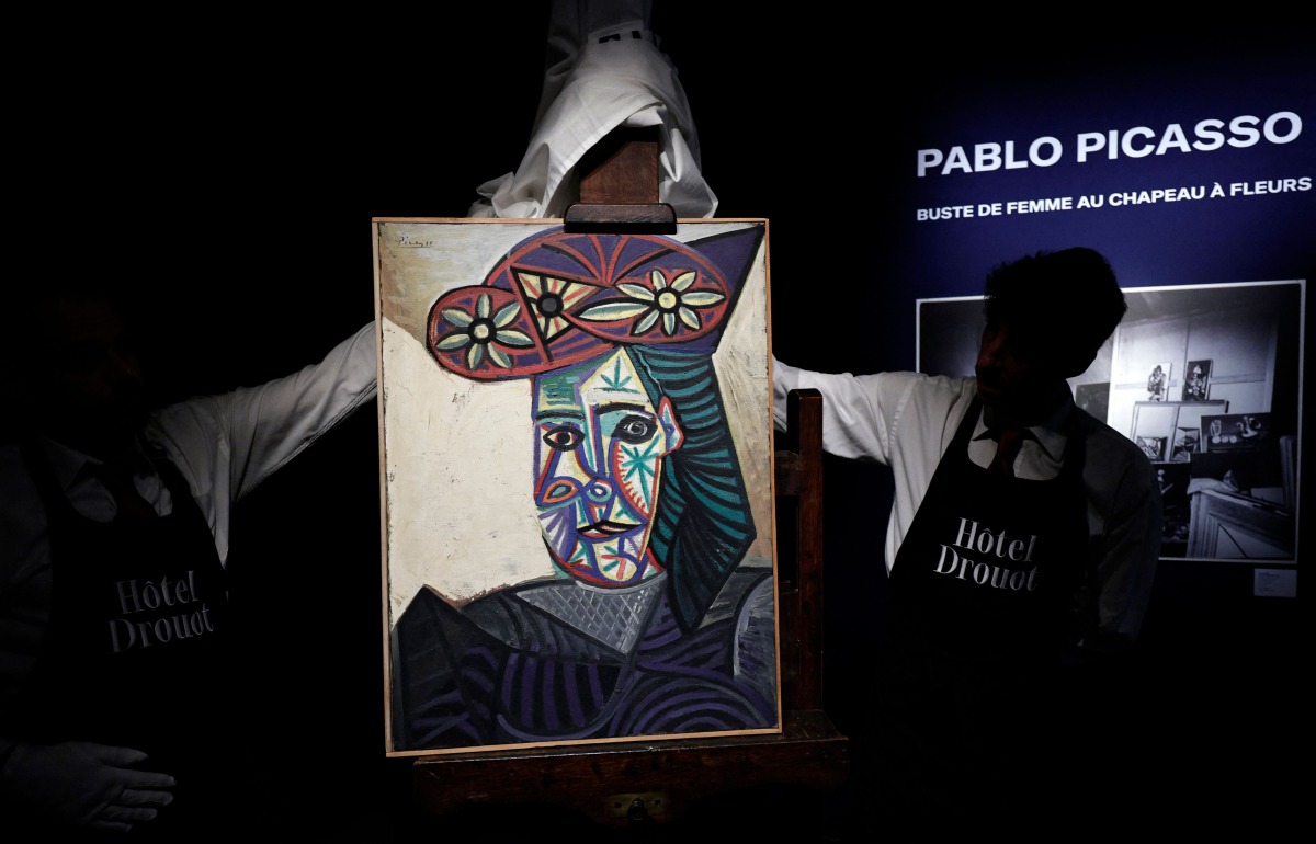 Employees unveal a painting by French artist Pablo Picasso titled 