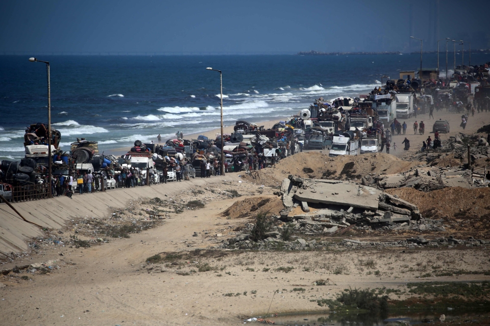 Palestinians from Gaza City move southwards with their belongings, on the coastal road near the Nuseirat refugee camp in the central Gaza Strip, on September 19, 2025. (Photo by Eyad Baba / AFP)