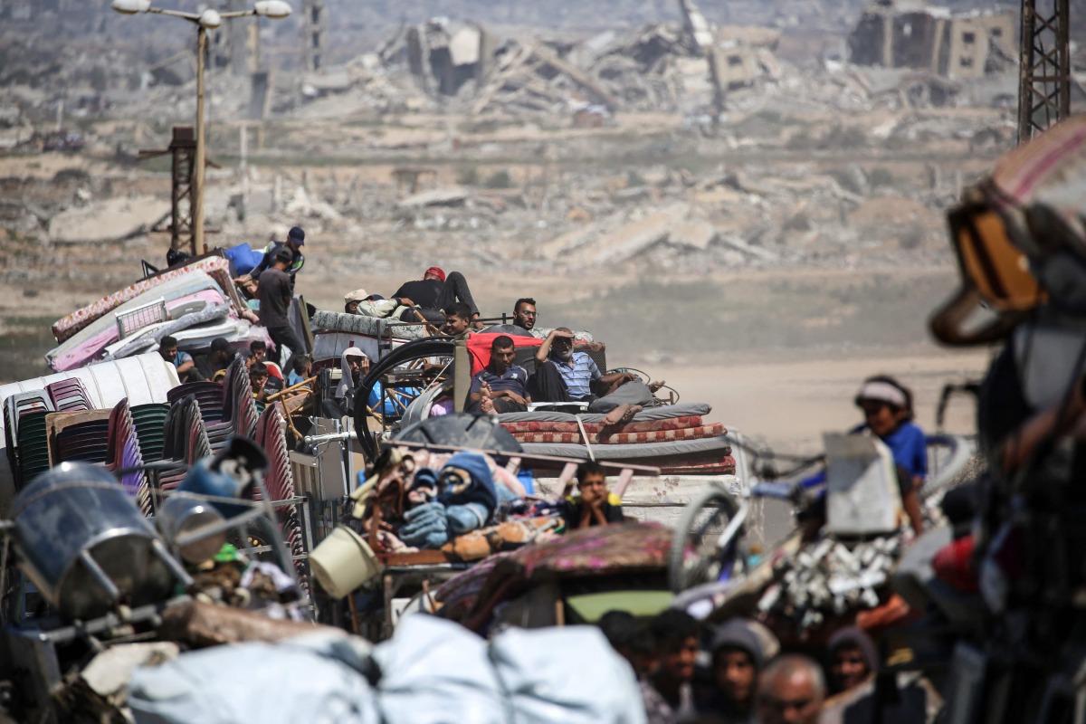 Palestinians from Gaza City move southwards with their belongings, on the coastal road near the Nuseirat refugee camp in the central Gaza Strip, on September 19, 2025. (Photo by Eyad BABA / AFP)
