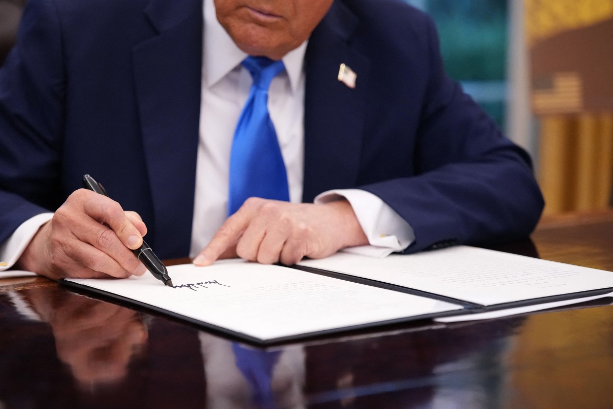 President Donald Trump signs an executive order in the Oval Office at the White House on September 19, 2025 in Washington, DC. Trump signed a series of executive orders establishing the “Trump Gold Card” and introducing a $100,000 fee for H-1B visas. (Photo by Andrew Harnik / GETTY IMAGES NORTH AMERICA / Getty Images via AFP)
