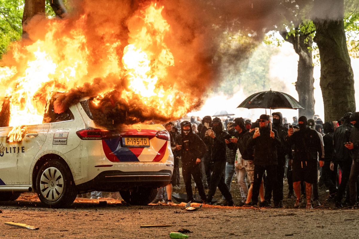 A police car is set on fire during the 