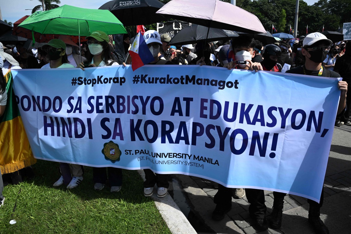 Protesters hold a banner which reads 