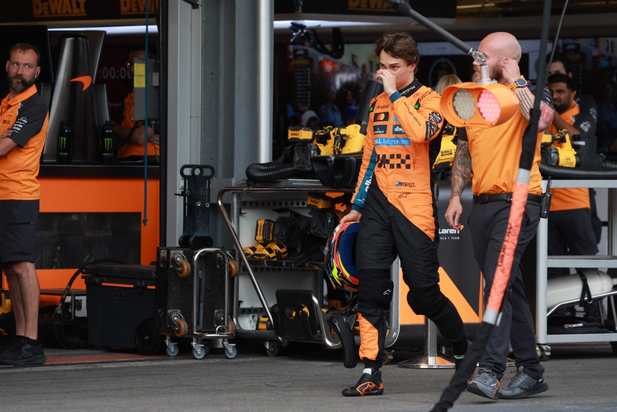 McLaren's Australian driver Oscar Piastri (L) walks in the pits after crashing during a qualifying session of the Formula One Azerbaijan Grand Prix at the Baku City Circuit in Baku on September 20, 2025. (Photo by Anton Vaganov / POOL / AFP)