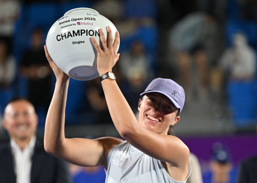 Iga Swiatek of Poland celebrates with the trophy after beating Ekaterina Alexandrova of Russia to win the women's singles final match at the Korea Open tennis tournament in Seoul on September 21, 2025. (Photo by Jung Yeon-je / AFP)