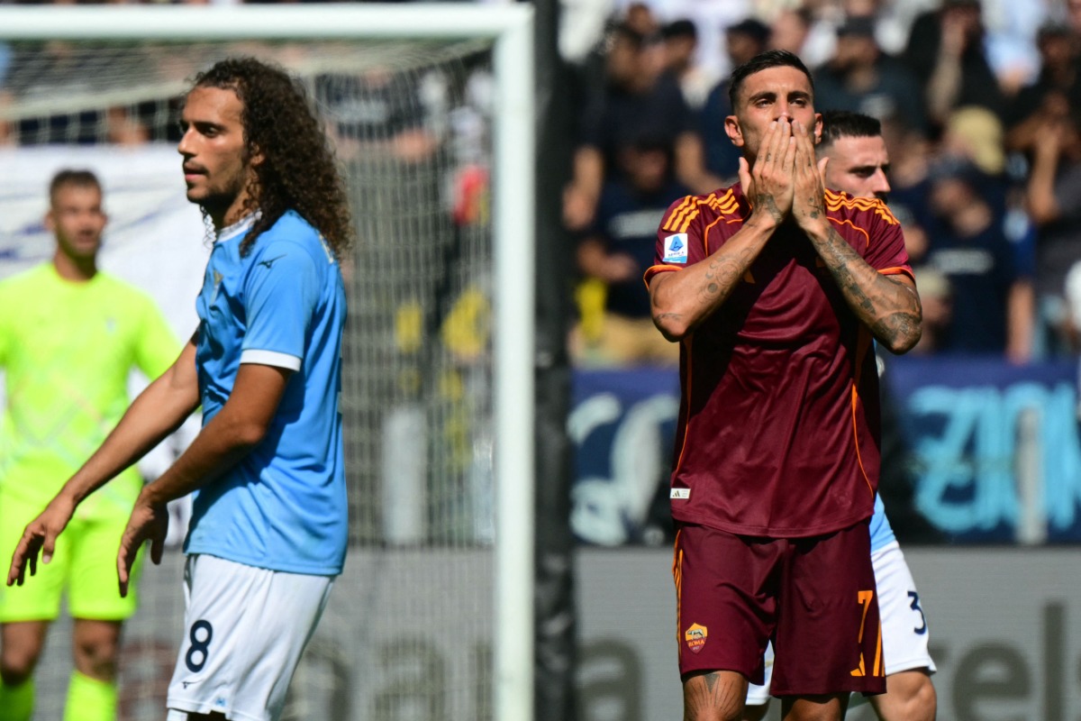 Roma's Italian midfielder #07 Lorenzo Pellegrini celebrates scoring his team's first goal next to Lazio's French midfielder #08 Matteo Guendouzi during the Italian Serie A football match between Lazio and Roma at the Olympic stadium in Rome, on September 21, 2025. (Photo by Tiziana FABI / AFP)