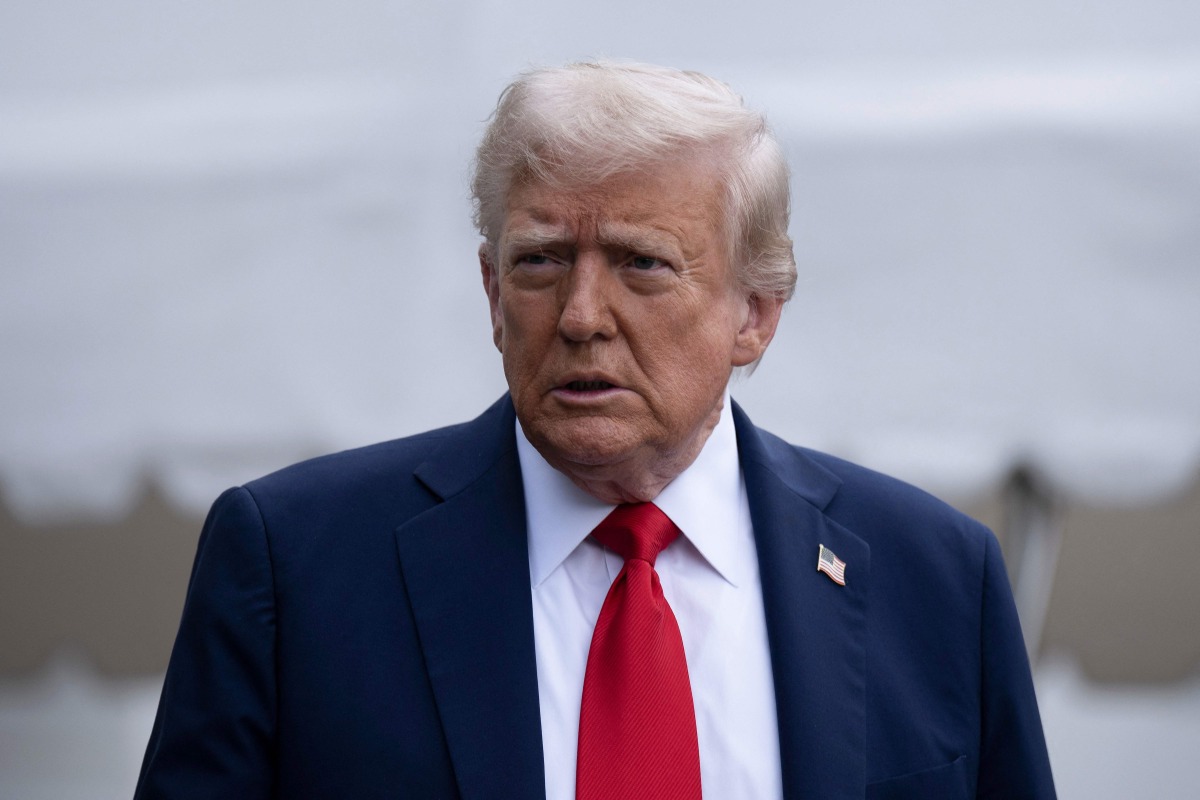 US President Donald Trump stops to speak with reporters while walking to Marine One on the South Lawn of the White House September 21, 2025, in Washington, DC. Trump is heading to Glendale, Arizona to attend the public memorial service for Charlie Kirk. (Photo by Brendan Smialowski / AFP)
