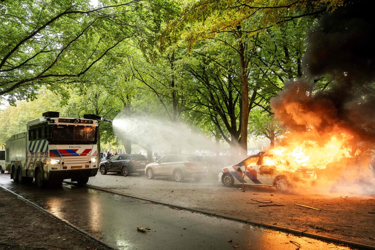 A police car is set on fire during the 