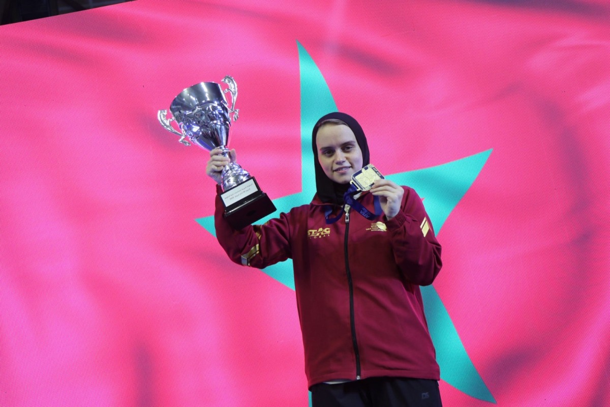 Aya Mohamed celebrates with her trophy and medal.