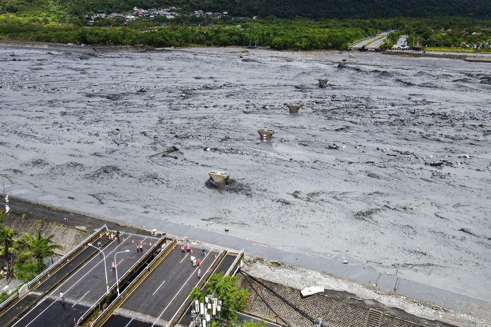 An overview shows flowing mud and floodwaters after a barrier lake burst and caused parts of the bridge over Mataian Creek be destroyed in Hualien on September 24, 2025. (Photo by Taiwan's Central News Agency (CNA) / AFP)