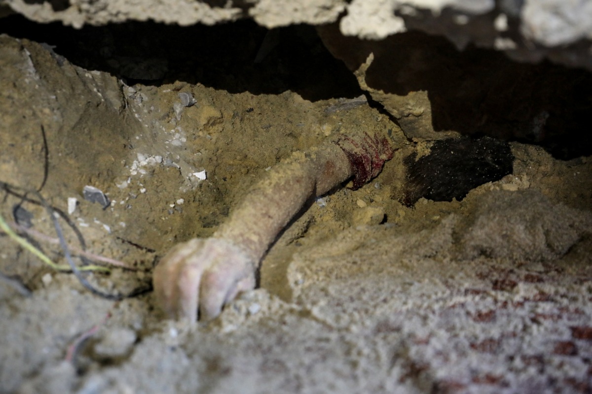 Graphic content: The body of child lies buried under the rubble of a building hit by an Israeli strike in the Nuseirat refugee camp in the central Gaza Strip, on September 25, 2025, as Israel presses its air and ground offensive to capture the nearby Gaza City. (Photo by Eyad BABA / AFP)

