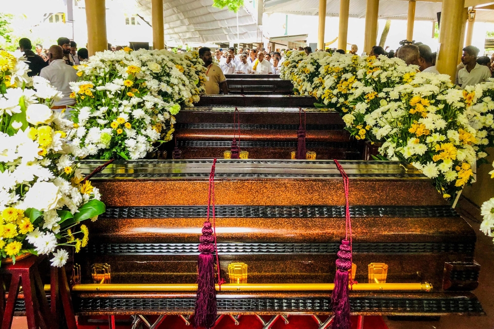 People gather near the coffins of Buddhist monks during a funeral ceremony at the Na Uyana Monastery in Melsiripura on September 27, 2025. (Photo by AFP)