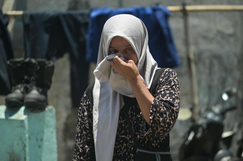A relative of a missing student mourns as rescuers search for survivors at the Al Khoziny Islamic boarding school in Sidoarjo, East Java province on October 2, 2025. (Photo by Juni Kriswanto / AFP)
 