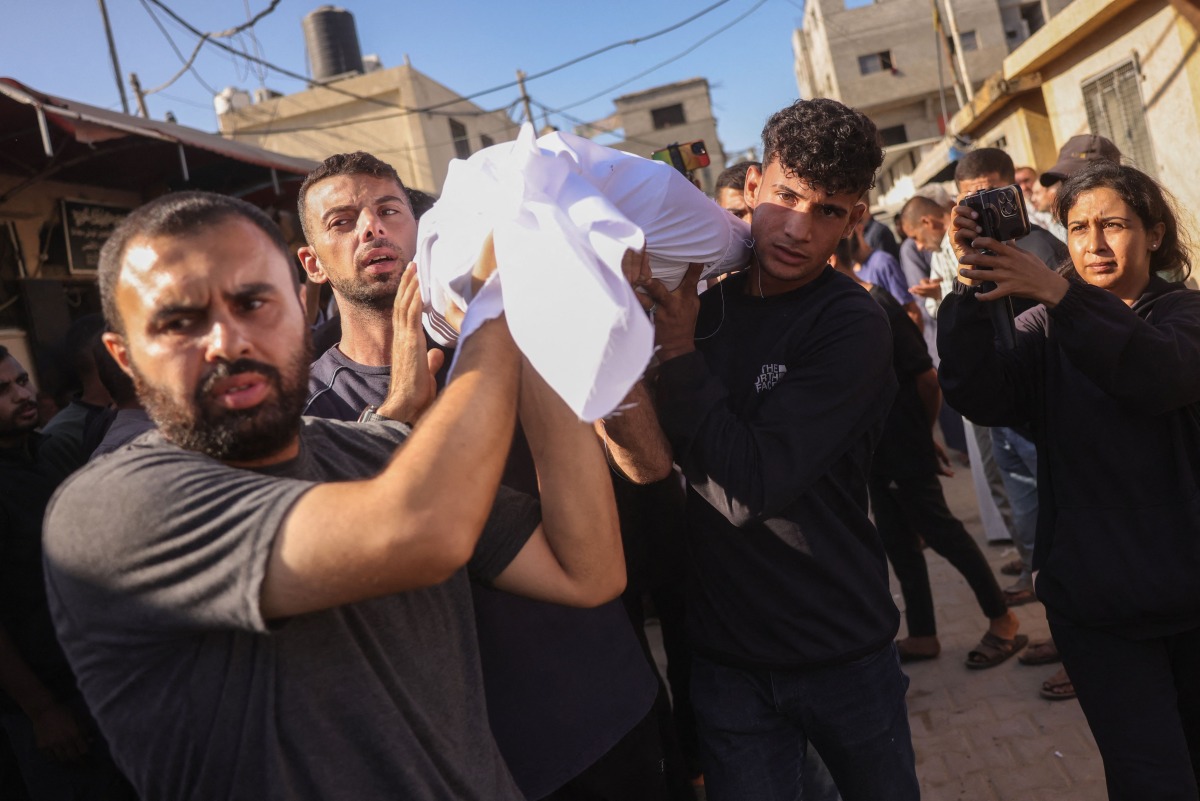 Palestinians carry the body of a man killed in an Israeli strike, during a funeral procession outside al-Aqsa Martyrs hospital in Deir el-Balah in the central Gaza Strip, on October 1, 2025. (Photo by BASHAR TALEB / AFP)
