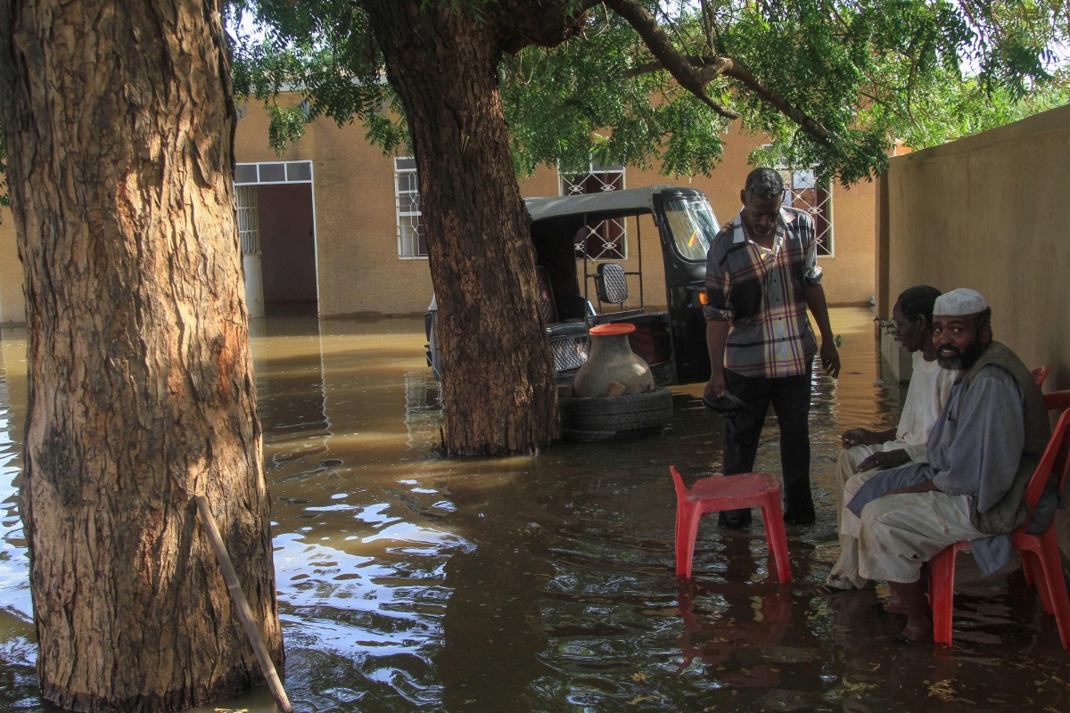 Residents sit in a pool of water due to the flooding of the Nile river in the Sudanese village of Wad Ramli north of Khartoum on October 1, 2025. (Photo by Ebrahim Hamid / AFP)
