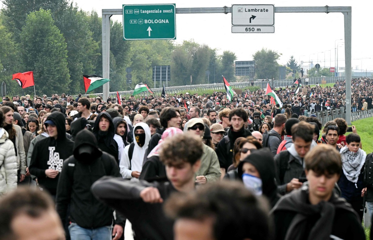 Pro-Palestinian demonstrators march during the protest on the Milan's highway against the interception of the Global Sumud Flotilla, on October 3, 2025. (Photo by Stefano RELLANDINI / AFP)