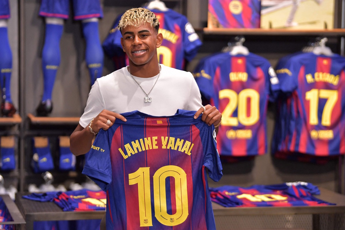 Barcelona's Spanish forward Lamine Yamal poses holding his new #10 jersey at the Camp Nou stadium's shop on July 16, 2025 in Barcelona. (Photo by Manaure Quintero / AFP)

