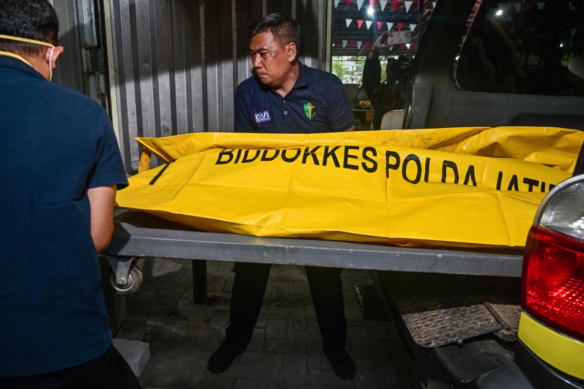 Police officials transfer the remains of a student, killed in a building collapse at the Al Khoziny Islamic boarding school, to a morgue at the Bhayangkara hospital in Surabaya, East Java province on October 4, 2025. (Photo by Juni KRISWANTO / AFP)