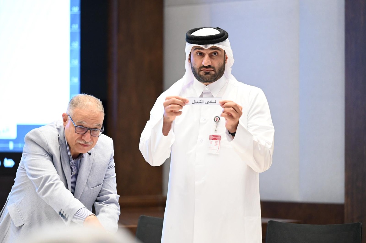 An official picks a team during the official draw ceremony.