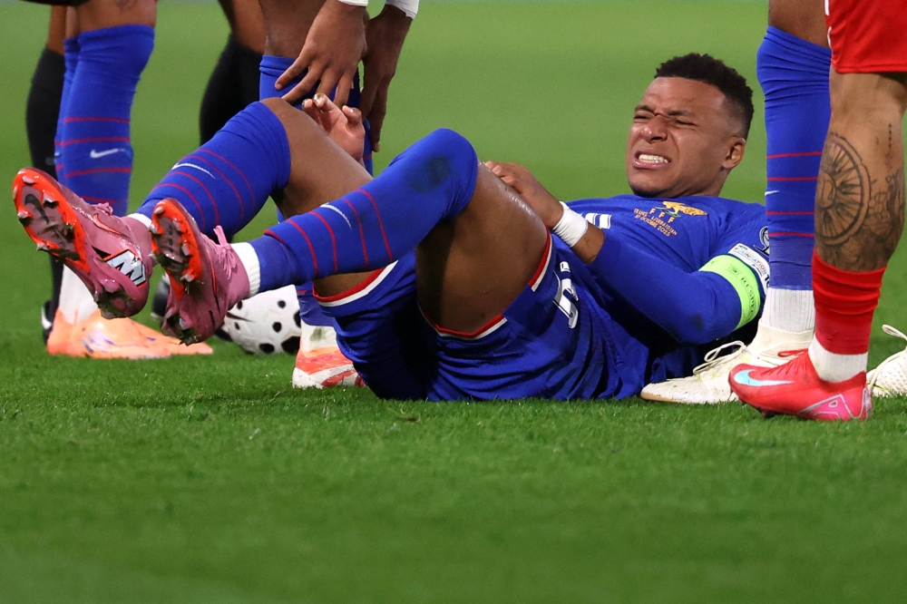 France's forward #10 Kylian Mbappe (C) reacts as he lies on the pitch during the FIFA World Cup 2026 Group D European qualification football, on October 10, 2025. (Photo by Anne-Christine POUJOULAT / AFP)