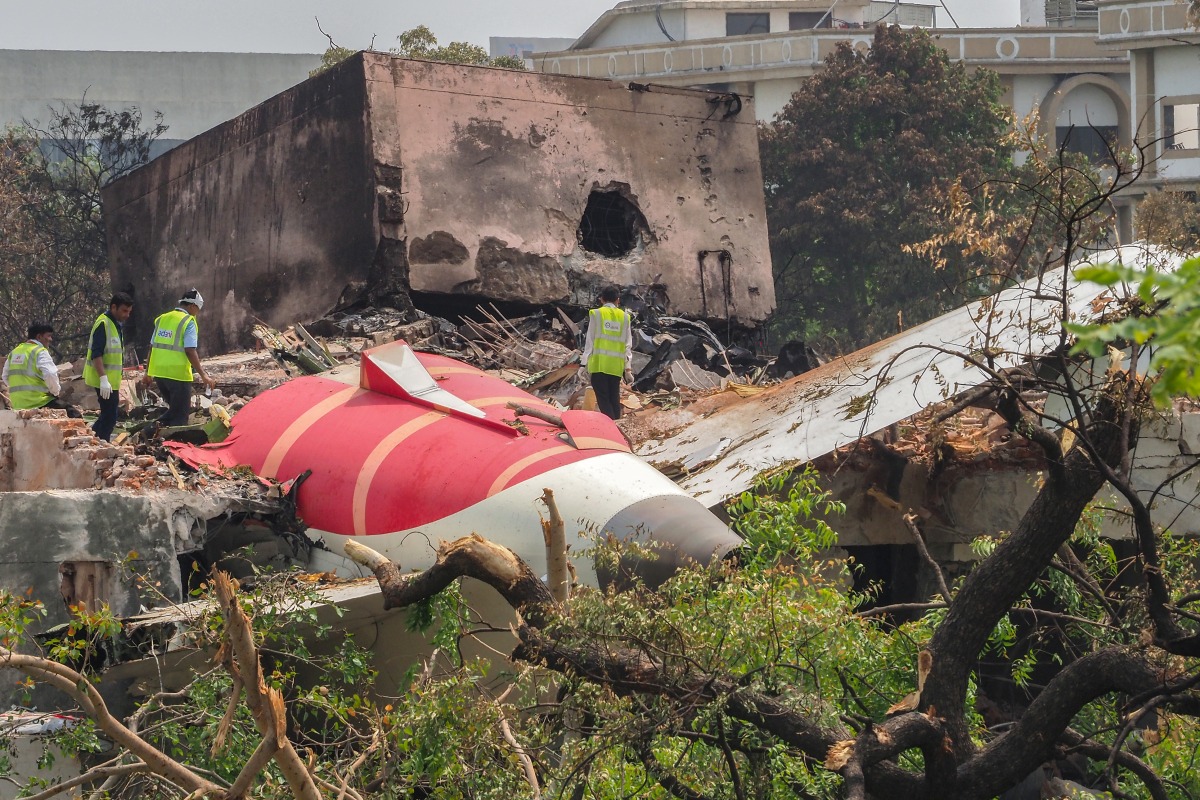 An investigation team inspects the wreckage of Air India flight 171 a day after it crashed in a residential area near the airport, in Ahmedabad on June 13, 2025. Photo by Sam PANTHAKY / AFP.

