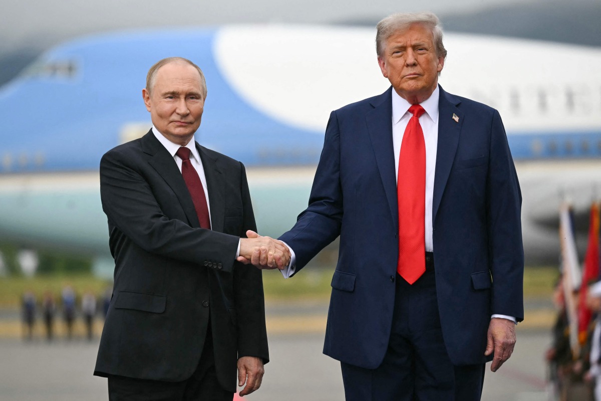 (FILES) US President Donald Trump greets Russian President Vladimir Putin on the tarmac after they arrived at Joint Base Elmendorf-Richardson in Anchorage, Alaska, on August 15, 2025. 