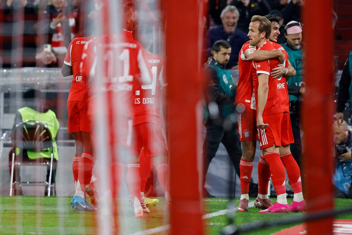 Bayern Munich's English forward #09 Harry Kane celebrates scoring the opening goal with his teammates during the German first division Bundesliga football match FC Bayern Munich vs BVB Borussia Dortmund, in Munich, southern Germany on October 18, 2025. (Photo by Alexandra BEIER / AFP)